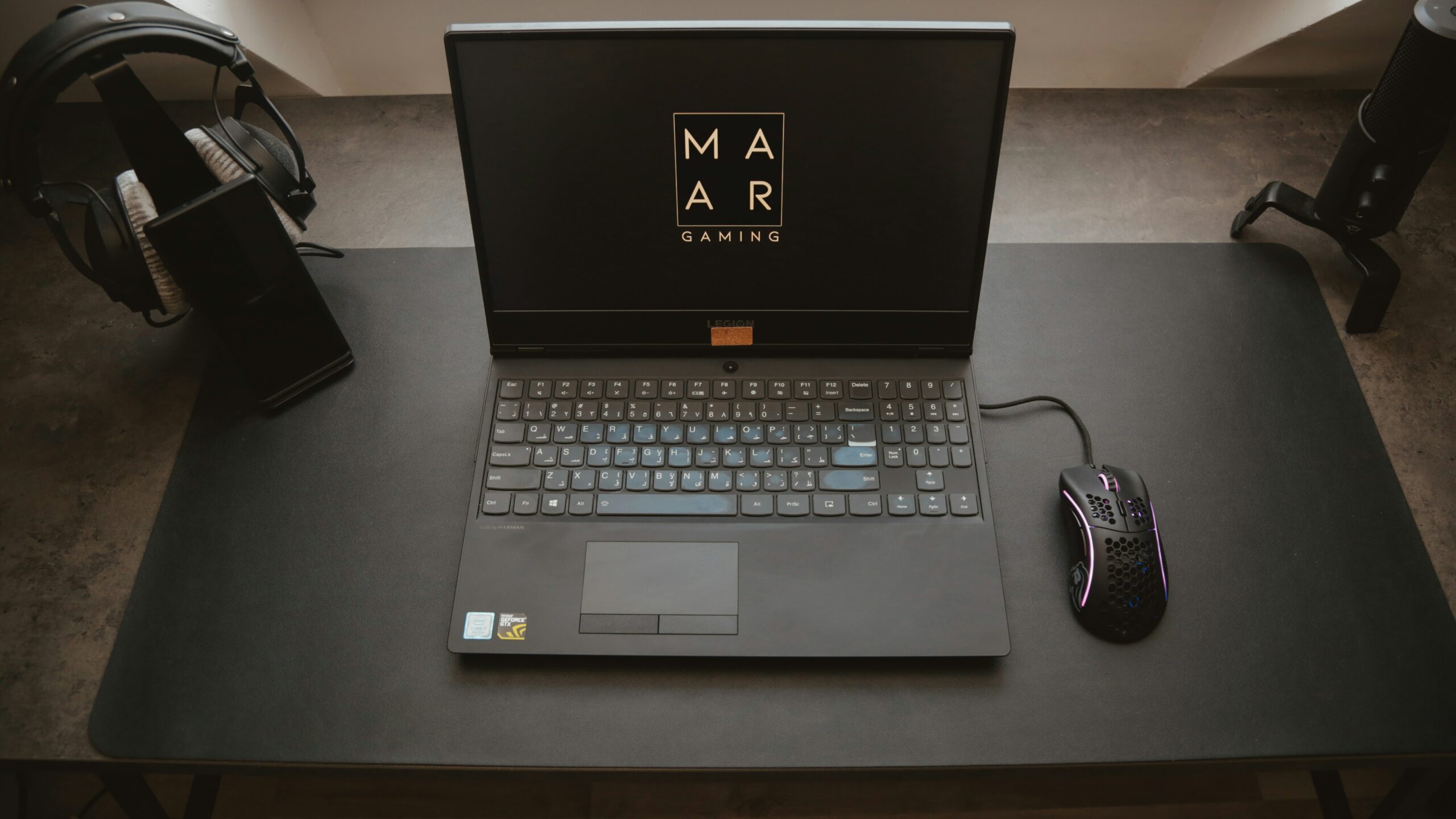 Gaming setup with laptop, mouse, and headphones.
