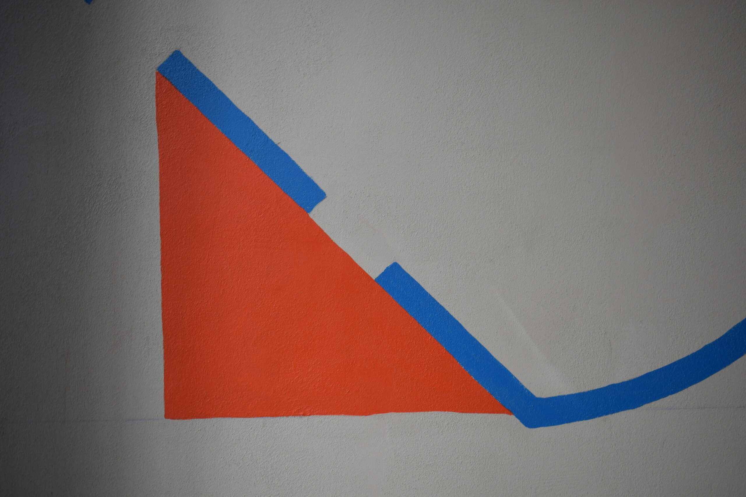 Abstract composition with orange and blue shapes on gray background.