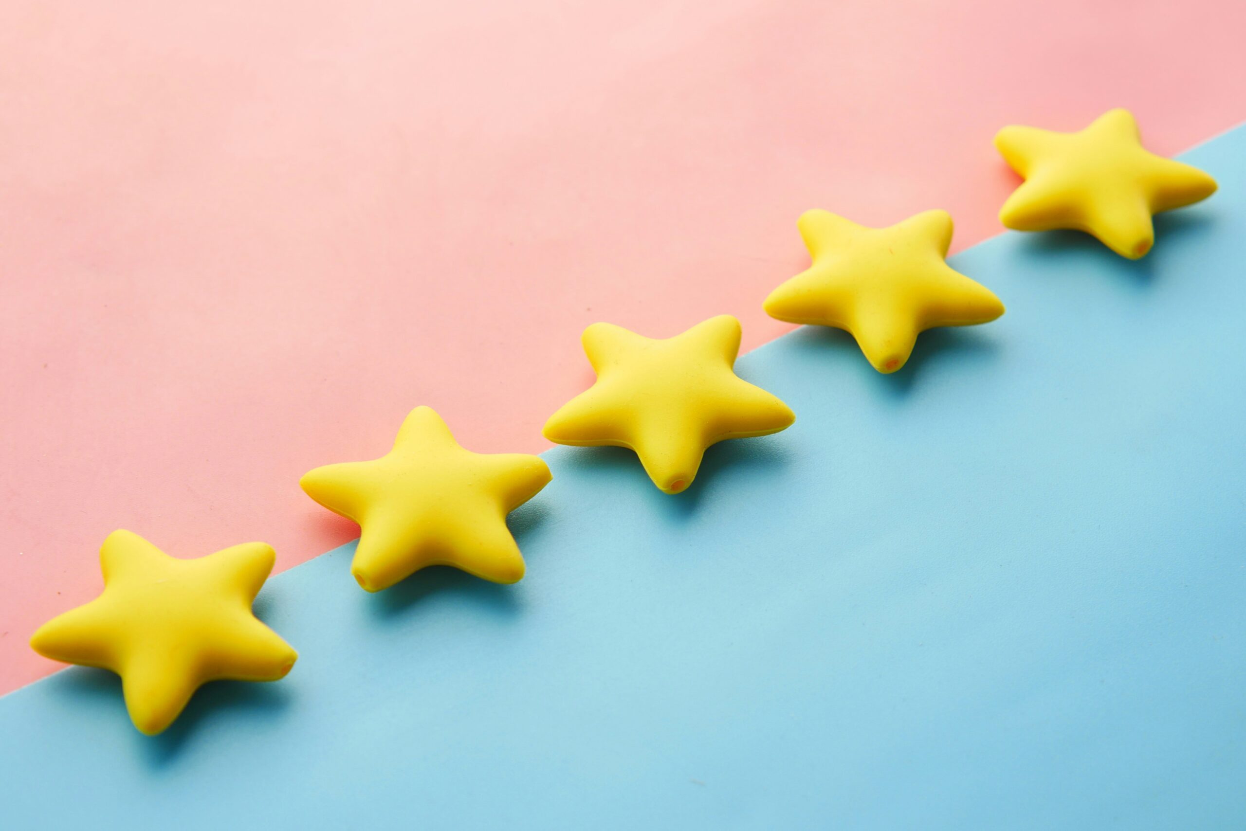 Five yellow stars on a pink and blue background. App Ranking and Marketing.