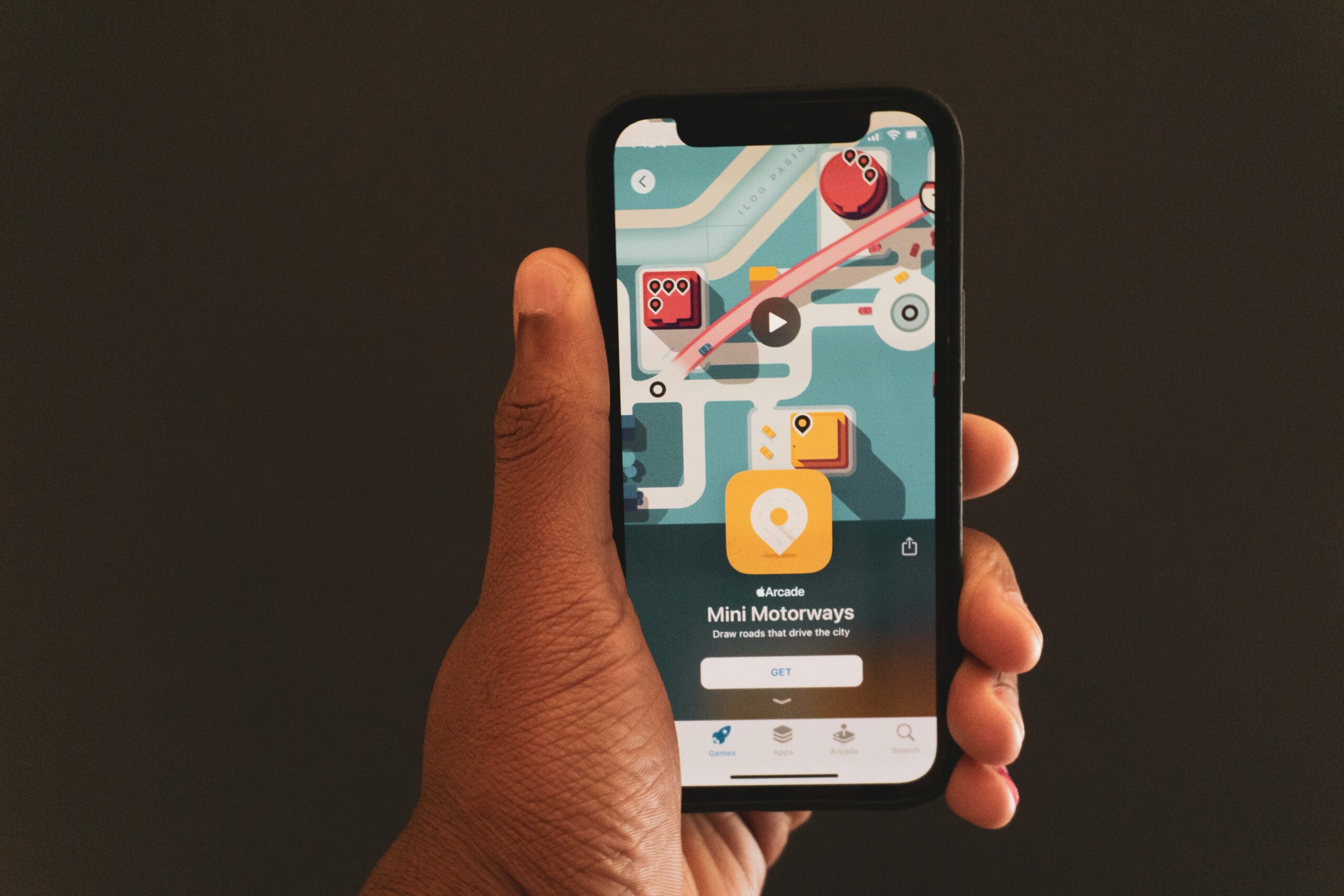 Person holding a phone with a game. Mobile app advertising, app install.