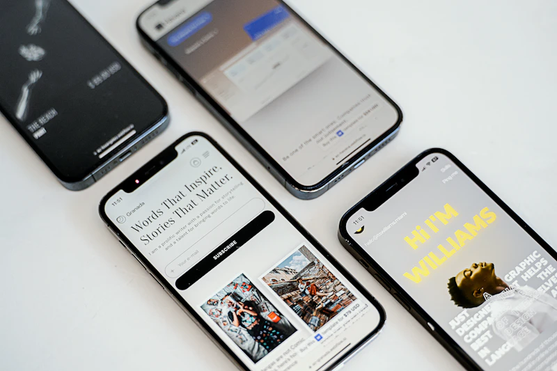 Four smartphones displaying different website designs.