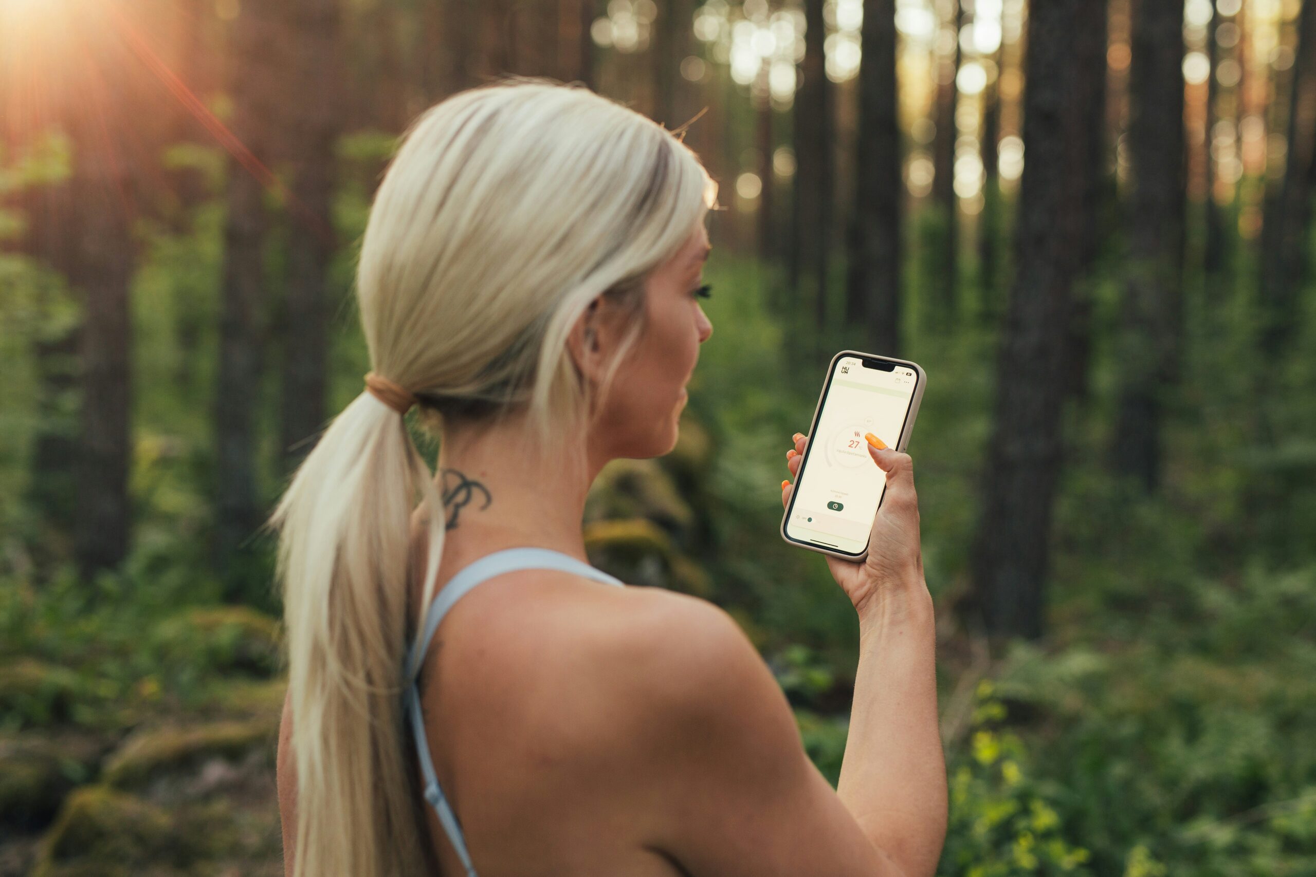 Woman in forest using a mobile app. Improve your app downloads with App Store Optimization.