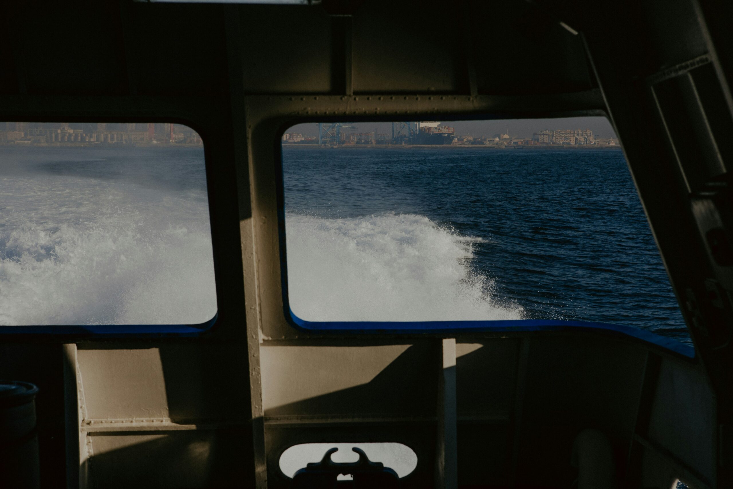 View from a boat window, showing the ocean and the city. 
