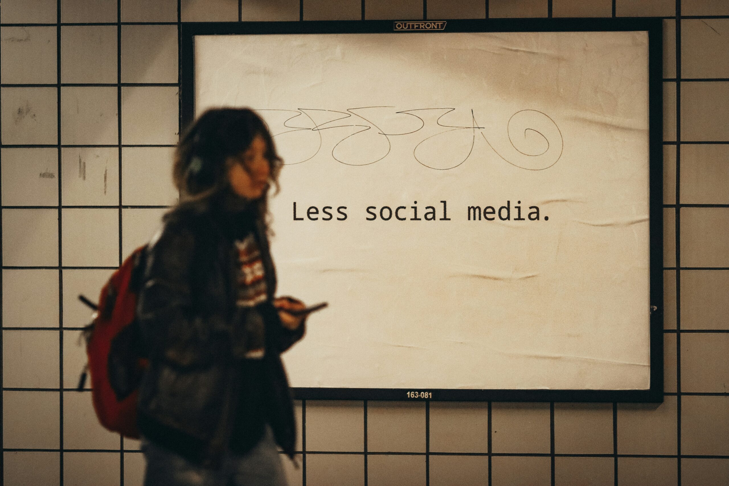 Woman walking past a sign that says 