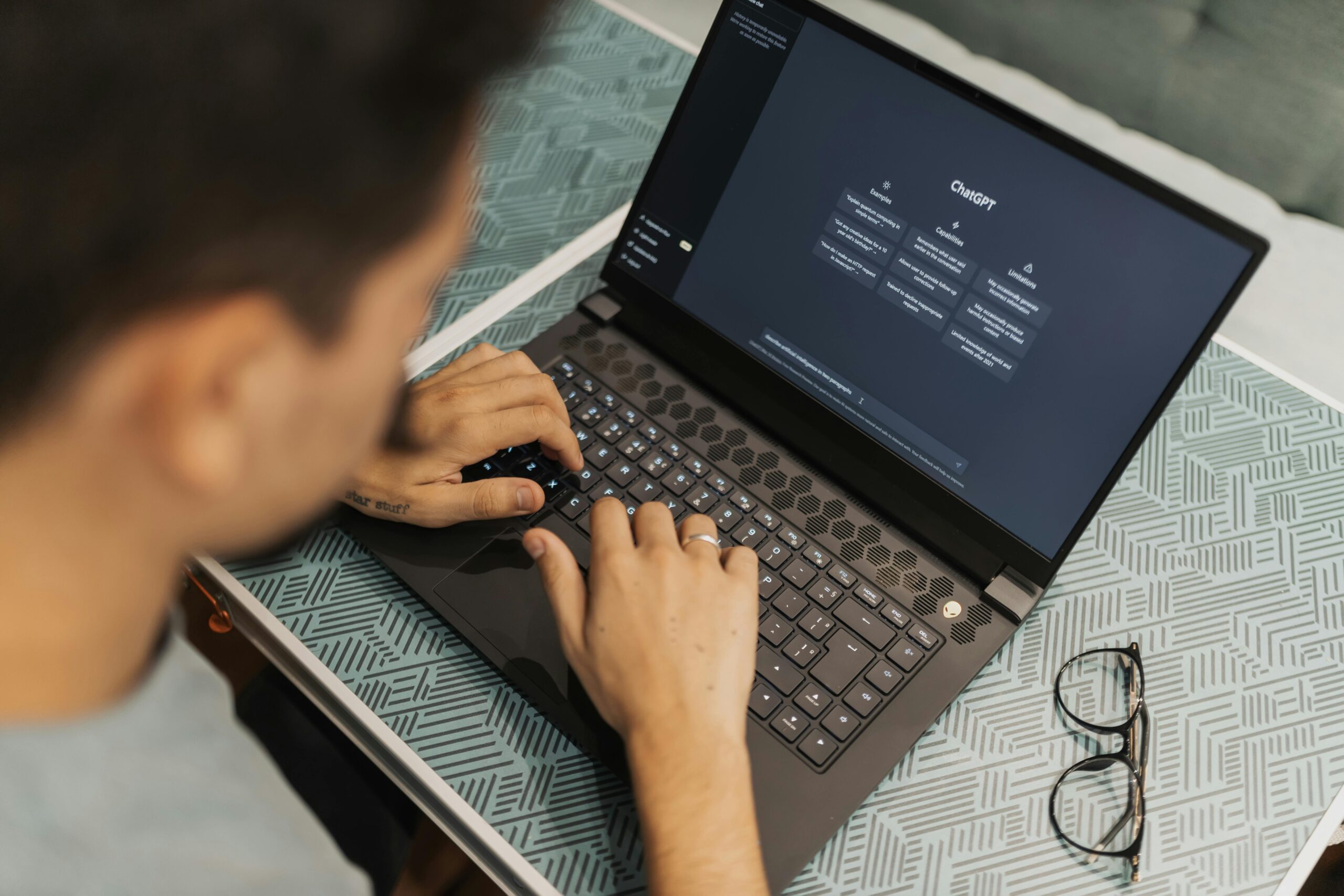 Person using laptop with ChatGPT interface. AI digital marketing tools.