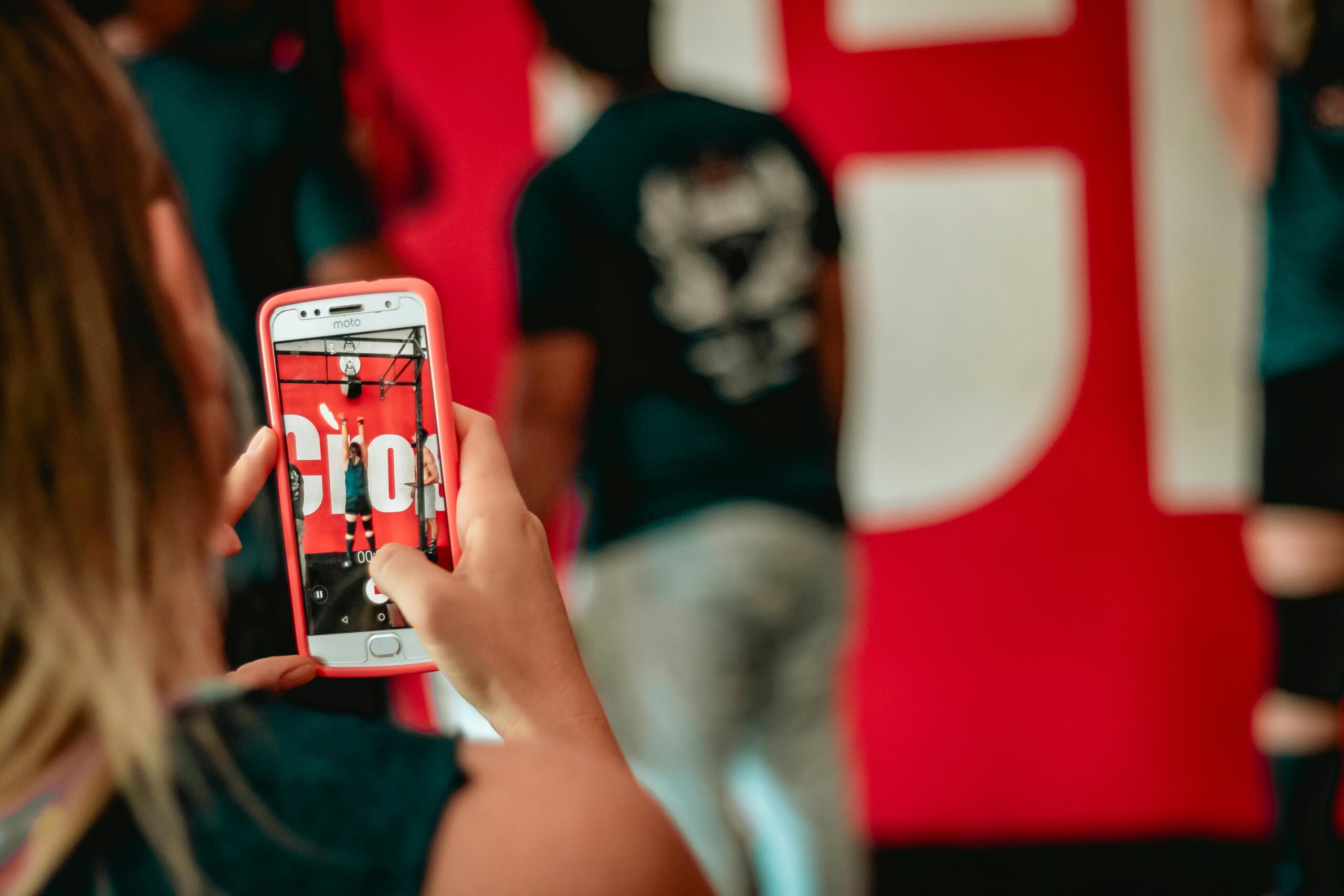 A smartphone displaying various social media platforms. The background should depict a social gathering or event to represent social engagement.