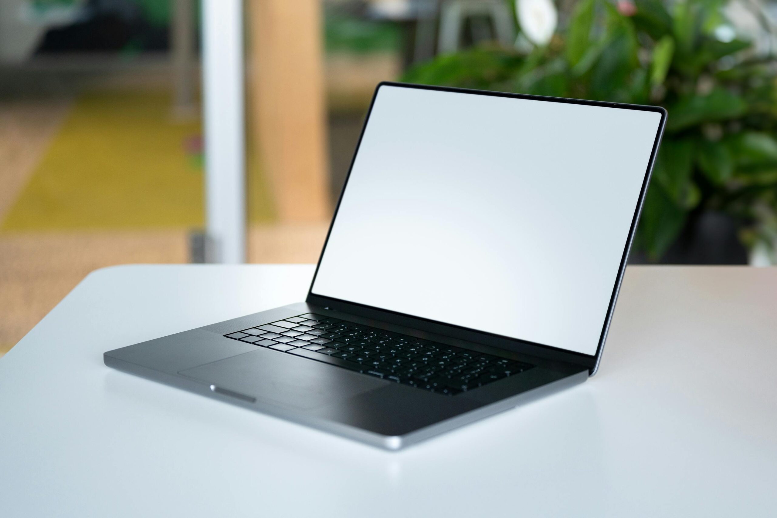 Laptop with blank screen on a white table.