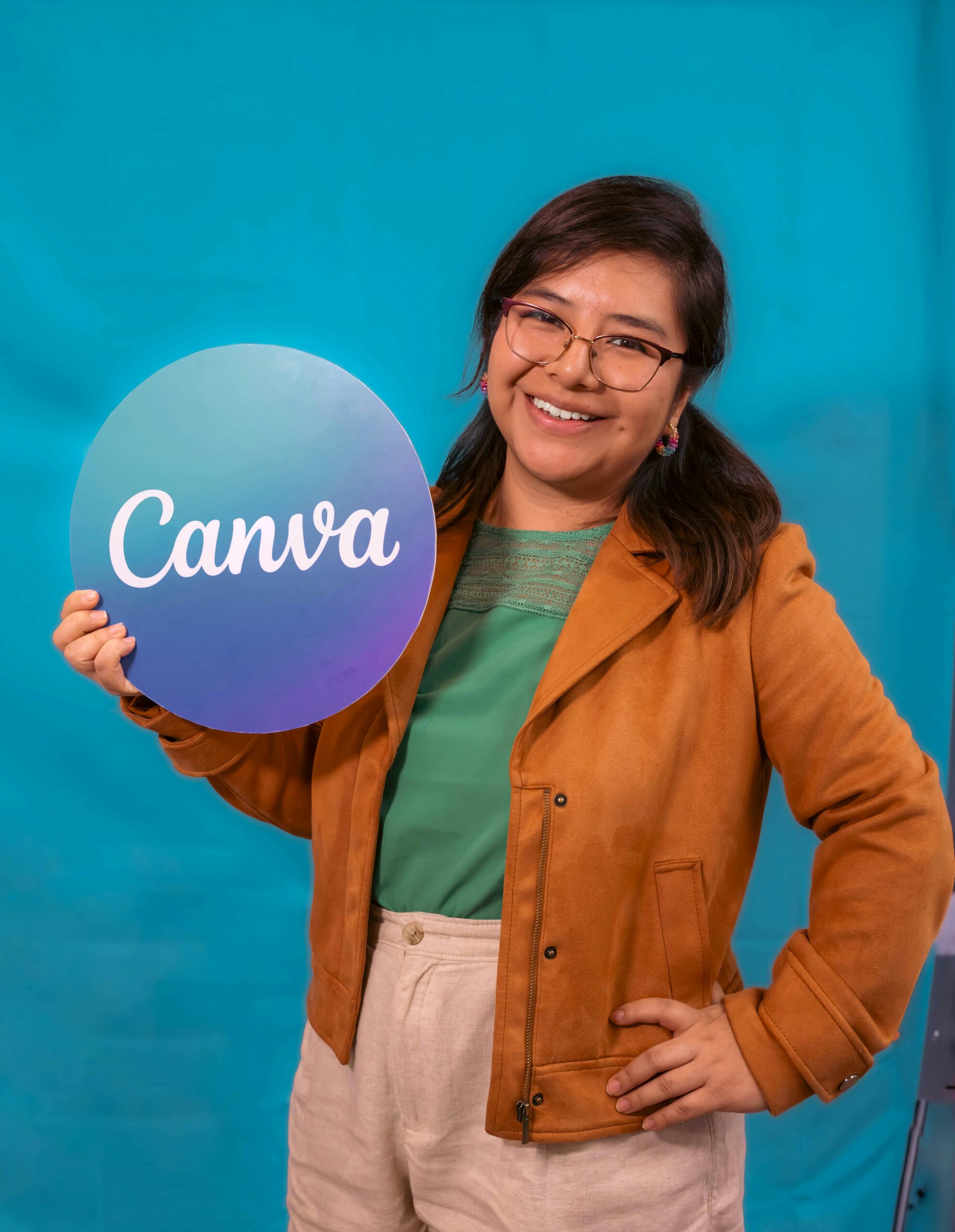Woman holding a Canva sign, a visual marketing tool.
