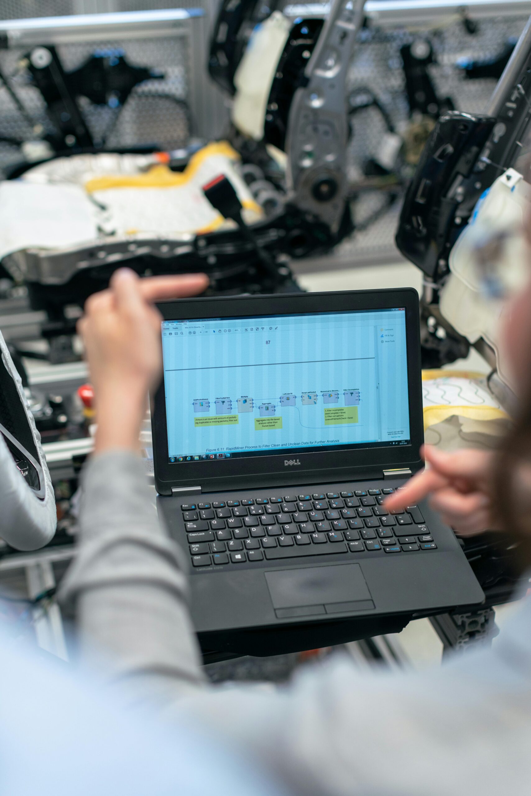 Two people collaborating on a Dell laptop.