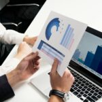 A dynamic image showcasing a businessperson confidently pointing towards a rising graph on a large screen, with a modern office setting in the background, and a soft, professional lighting.