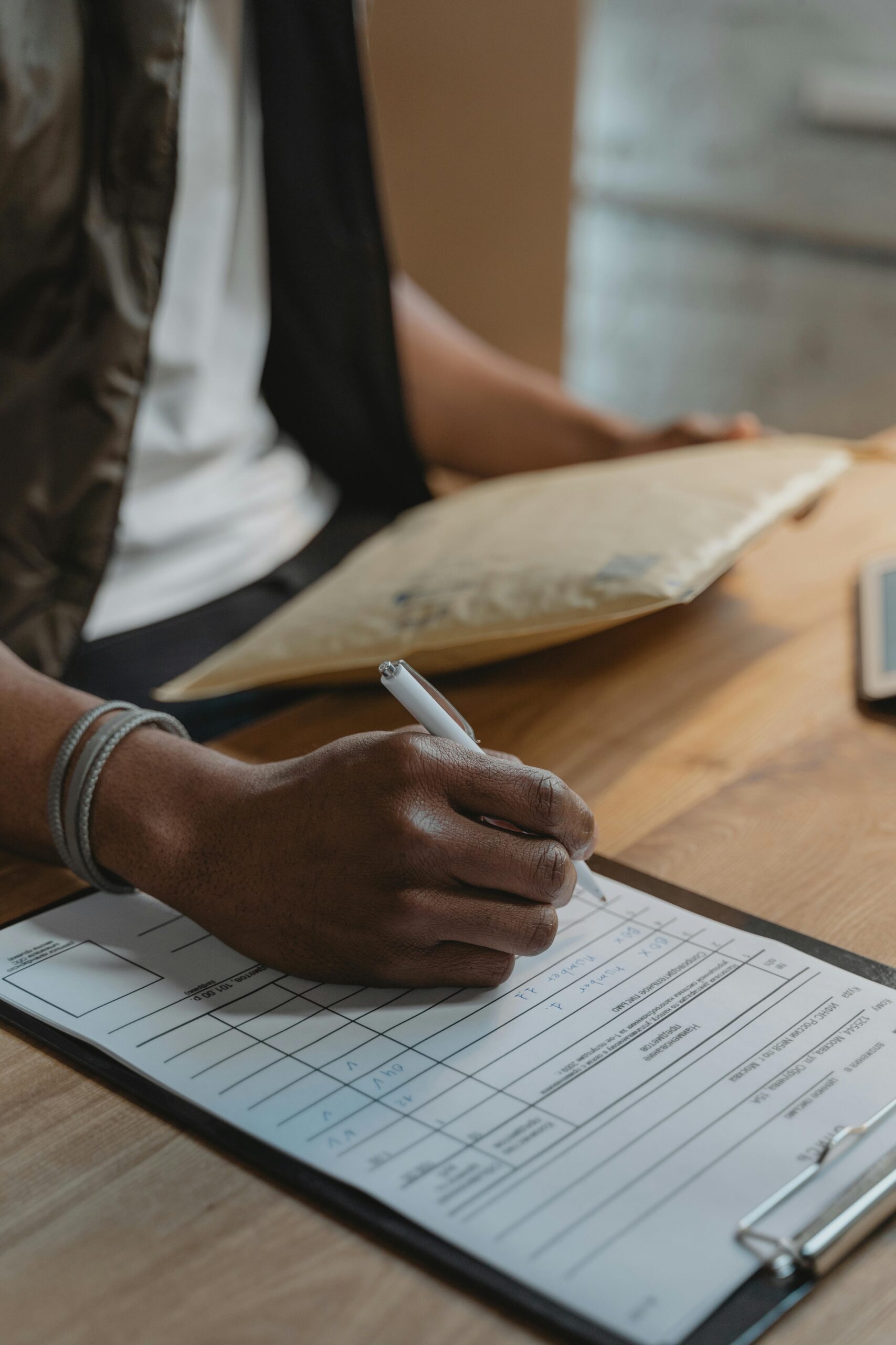 Person filling out a form, possibly for shipping or logistics.