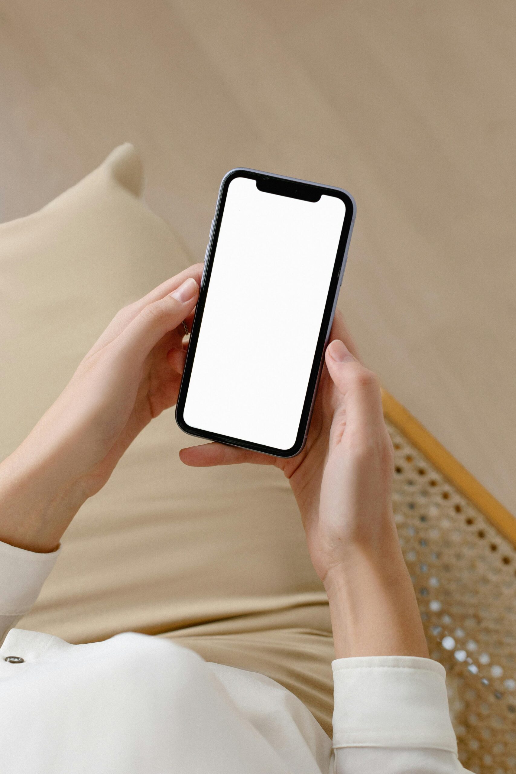 Person holding smartphone with blank screen.