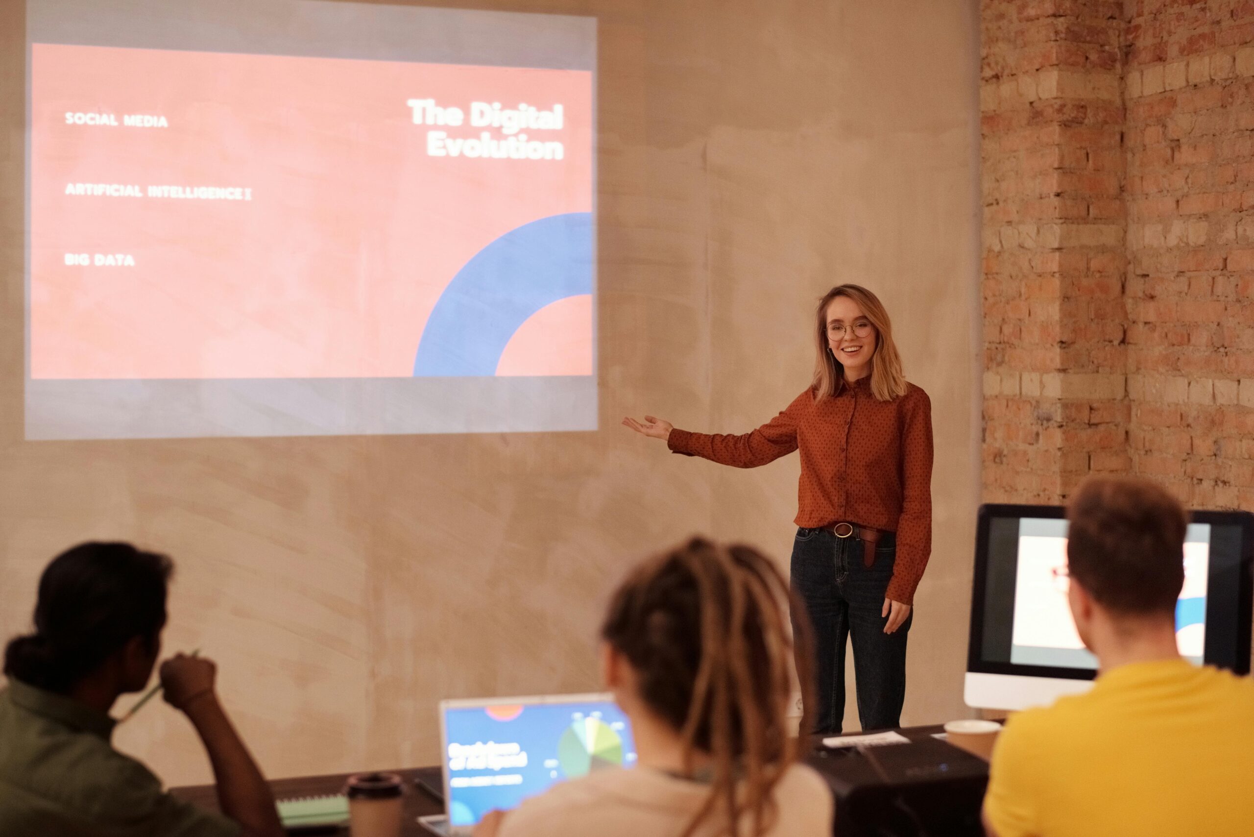 Woman presenting with a digital screen, discussing digital evolution.