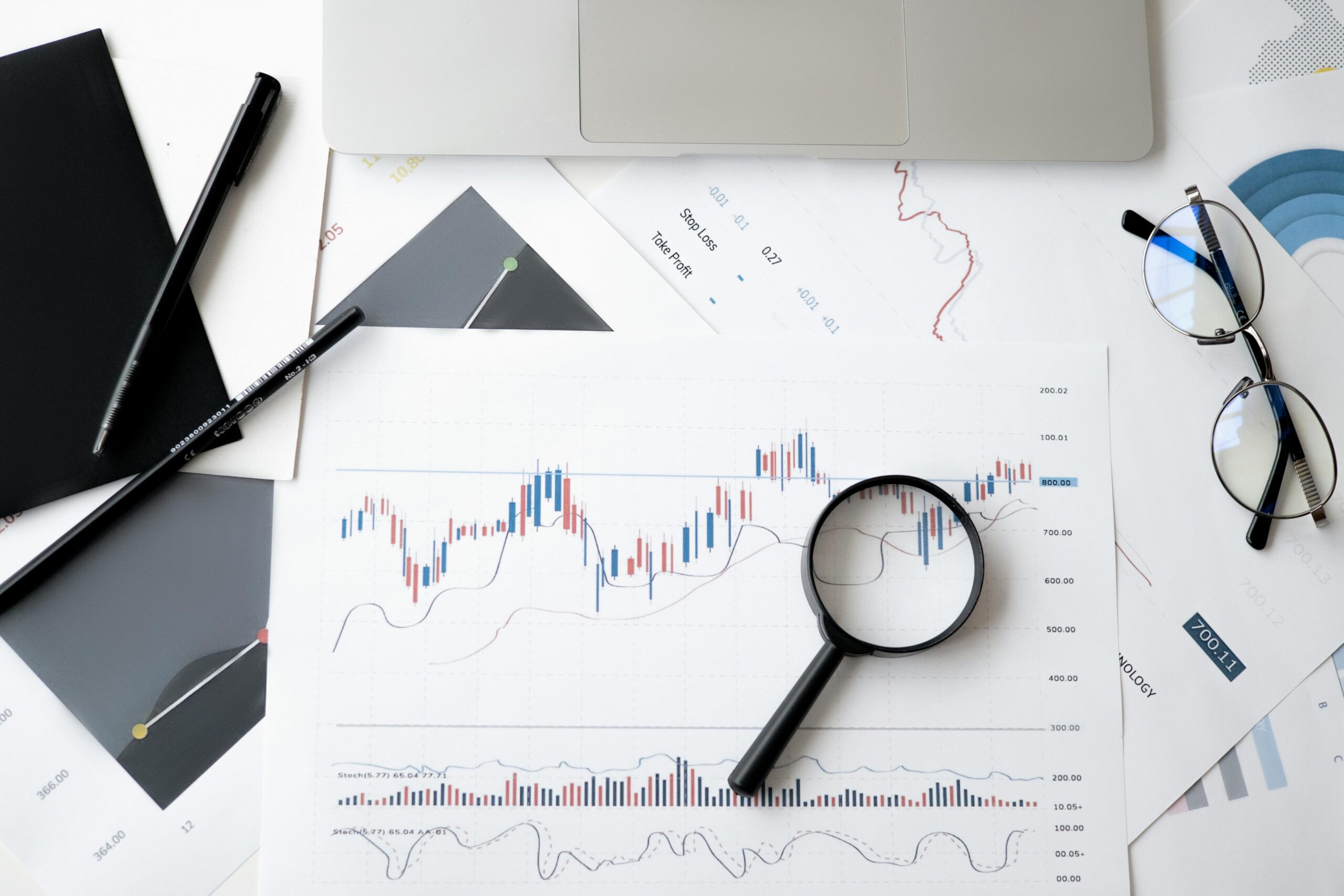 Financial chart analysis with magnifying glass.