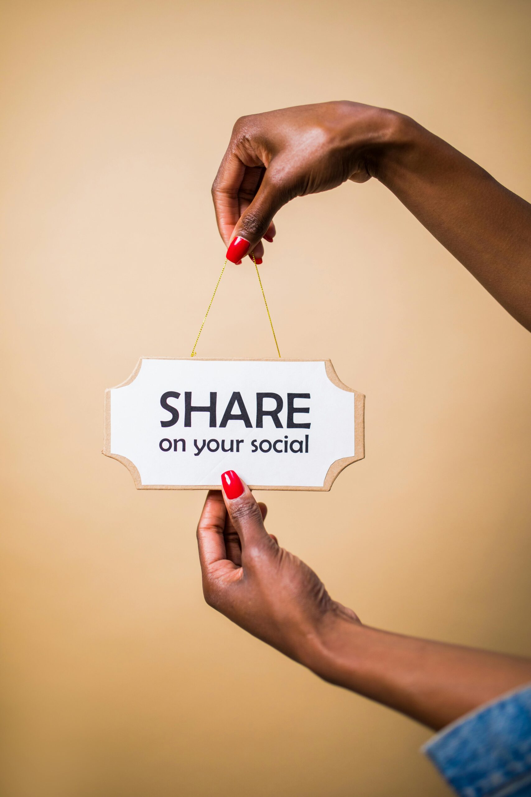 Person holding a sign that says 'Share on your social'. Social media marketing.