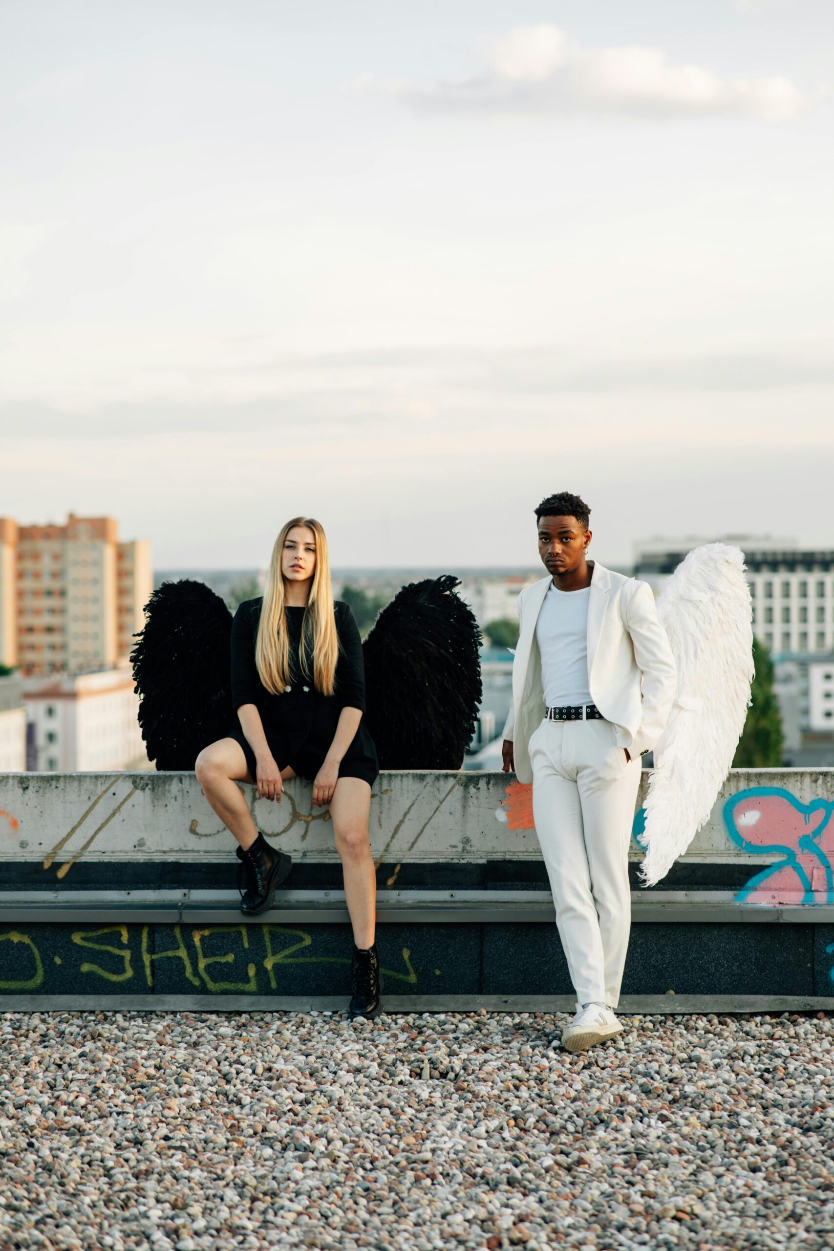 Man and woman with angel wings on a rooftop.