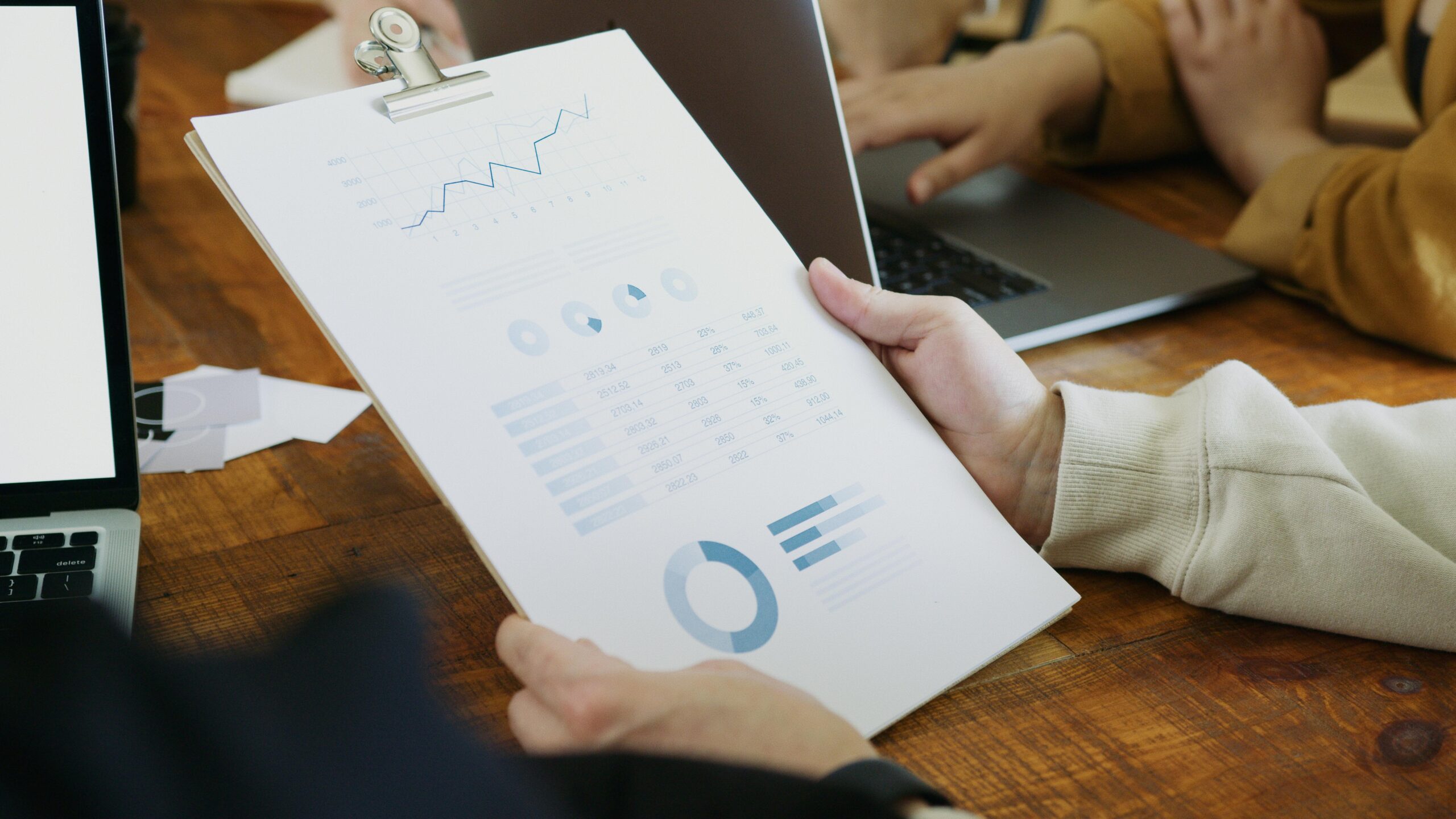 Person holding a clipboard with charts. Data analysis and marketing strategy.