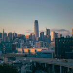 A dynamic cityscape of San Francisco at dusk, with digital icons overlaying the scene to represent digital marketing. The color scheme is modern, with blues and purples dominating.