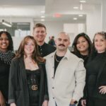 A diverse team of marketing professionals collaborating around a table, analyzing data on laptops and tablets. The scene should convey expertise, collaboration, and a focus on achieving results. The background should have a modern office setting with US-themed elements subtly incorporated, like a small American flag or artwork featuring US landmarks.