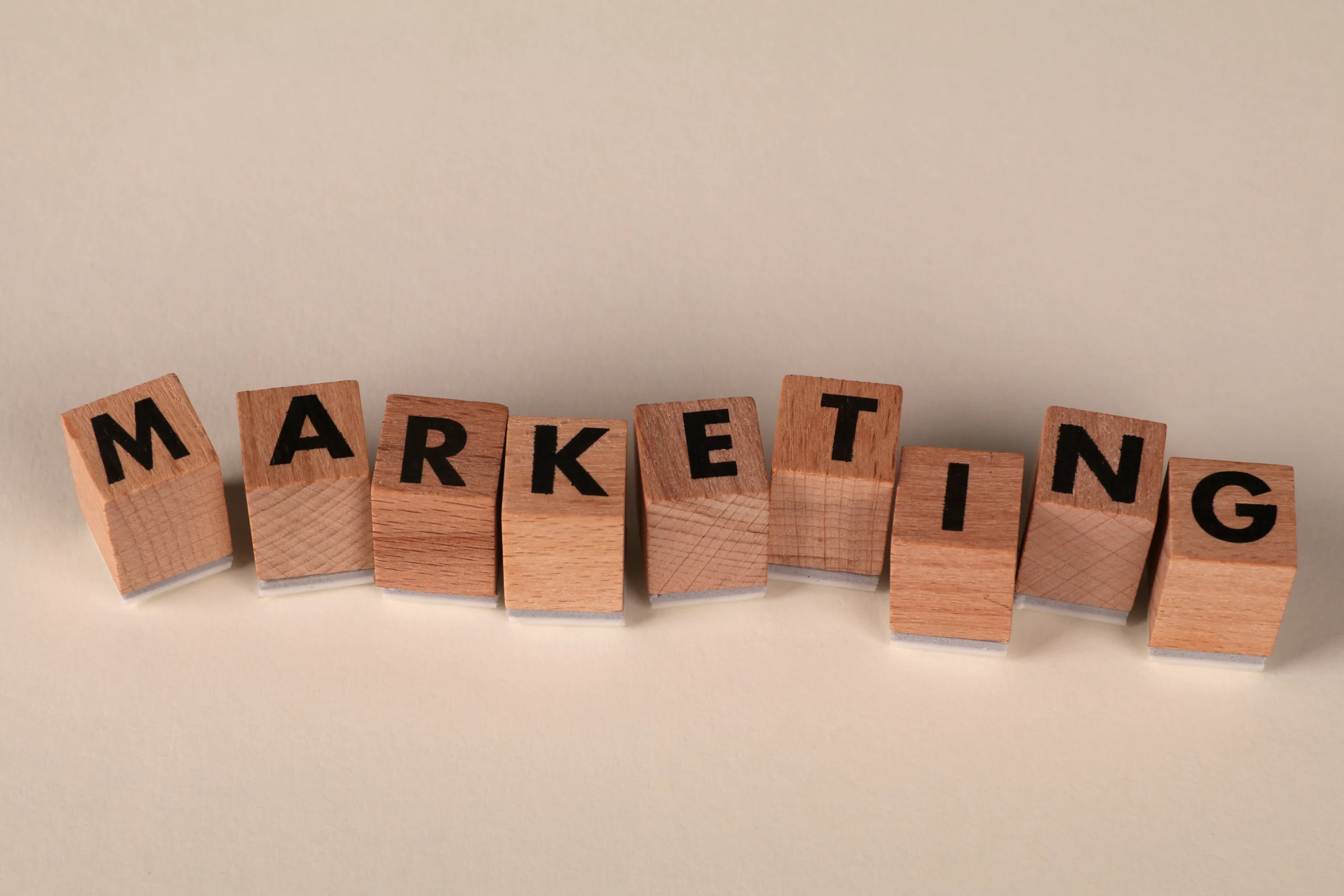 Wooden blocks spelling out 'MARKETING' representing the core service of a marketing agency, including native advertising services.