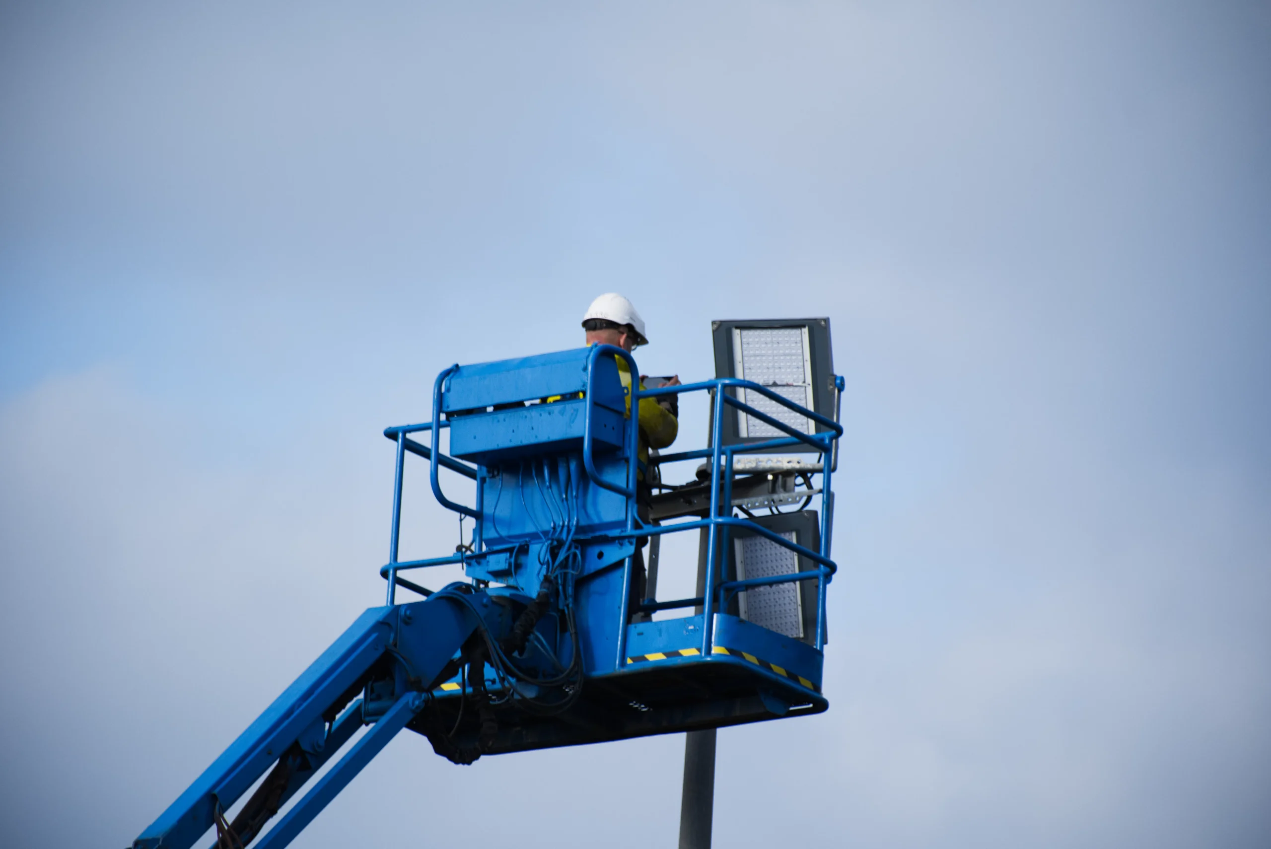 A worker in a bucket truck, symbolizing the behind-the-scenes effort to ensure native ad campaigns are effectively deployed and visible across various platforms, akin to maintaining a successful Taboola advertising presence.