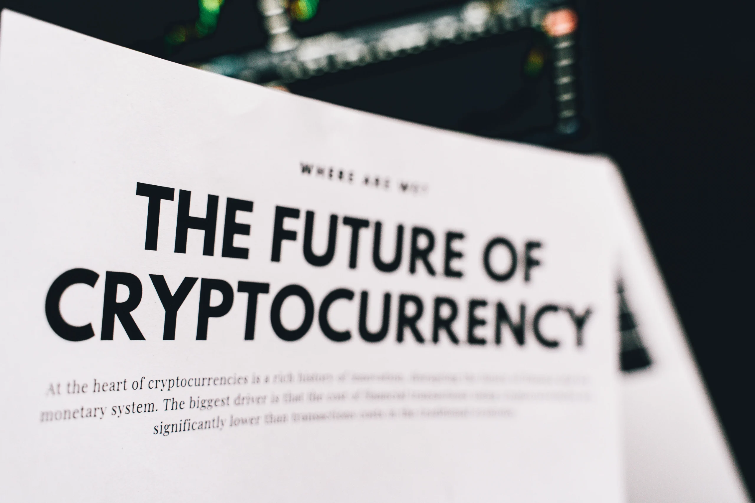 Close-up of a newspaper headline reading 'The Future of Cryptocurrency' against a dark background.