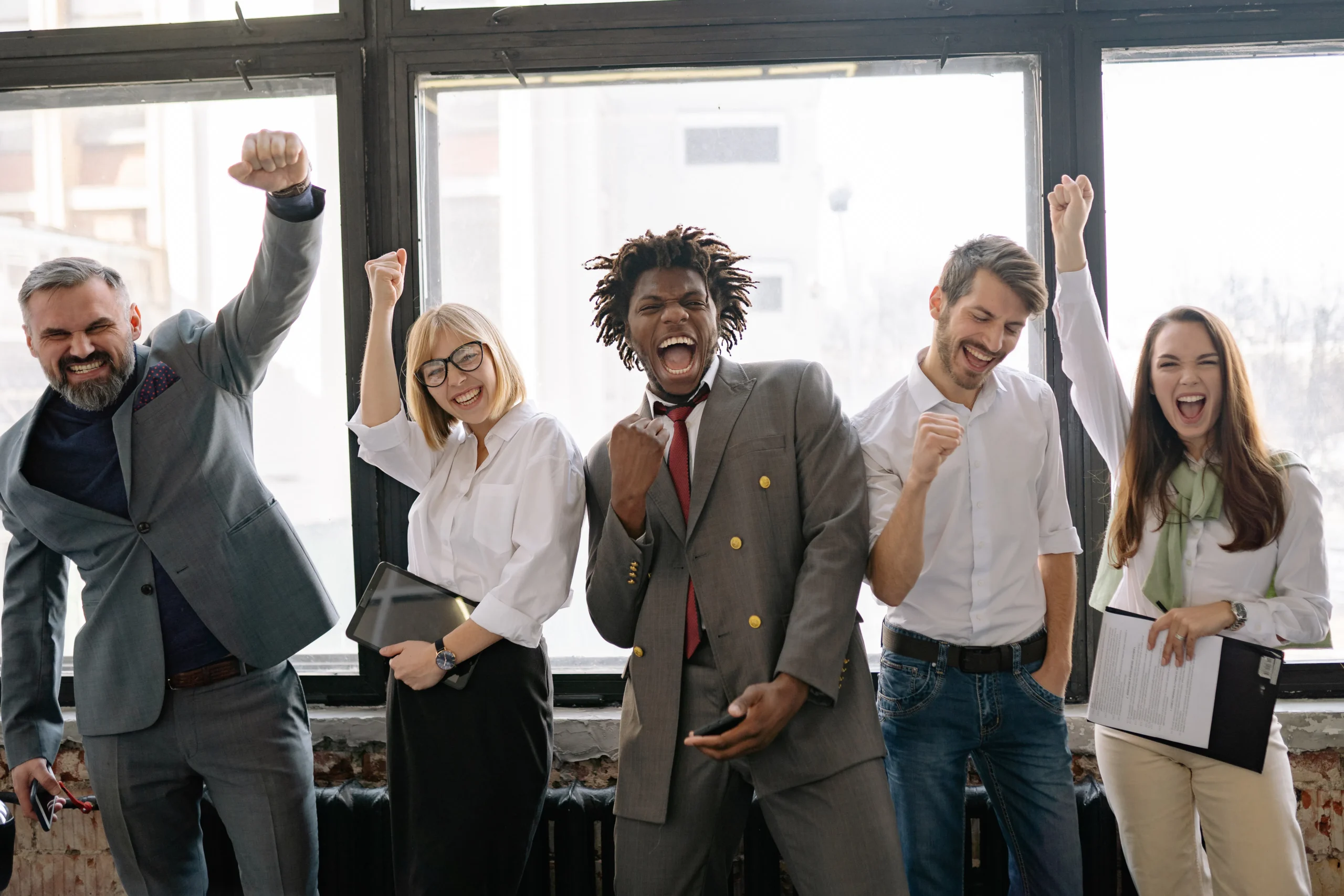 A diverse group of professionals celebrating success, signifying how Taboola for advertisers can help achieve goals and increase click-through rate with native advertising.