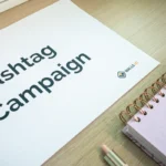 Hashtag campaign document on desk with Walls.io logo, notepad and pen.