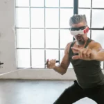 Man with VR headset fencing indoors with a foil, suggesting future tech applications.